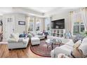 Bright living room with tray ceiling, hardwood floors, large windows and comfortable seating at 1048 Longwood Bluffs Circle, Murrells Inlet, SC 29576