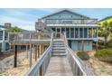 Beach home with wooden boardwalk leading to a screened porch and sundeck at 1184 Parker Dr., Pawleys Island, SC 29585