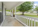 Inviting front porch with white railings, offering a pleasant view of the landscaped neighborhood at 119 Pickerel Blvd., Longs, SC 29568