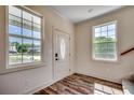 Bright foyer featuring wood-look flooring, a decorative front door, and ample natural light at 120 Triston Ct., Little River, SC 29566