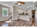Bright living room with ceiling fan, staircase, and view into the modern kitchen at 120 Triston Ct., Little River, SC 29566
