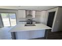 Modern kitchen with a center island, white cabinetry, stainless steel appliances, and ample counter space at 1300 Rabbit Ln., Conway, SC 29526