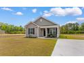 Inviting single-story home with gray siding, black shutters, and a concrete driveway at 1396 Highway 129, Galivants Ferry, SC 29544