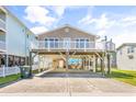 Inviting raised beach house with covered parking and white railings at 209 25Th Ave. N, North Myrtle Beach, SC 29582