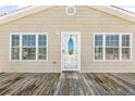 Charming home exterior featuring a front door flanked by windows and a spacious wooden deck at 209 25Th Ave. N, North Myrtle Beach, SC 29582