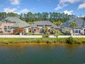 Water view of the home featuring a fenced backyard, and lush landscaping at 220 Waterfall Circle, Little River, SC 29566