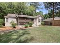 Inviting single-story home with a screened porch, set on a grassy lot with mature trees and a wooden fence at 2206 Beck St., Georgetown, SC 29440