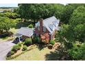 Aerial view of the beautiful brick home with a spacious yard featuring mature trees and lush landscaping at 402 E Broad St., Hemingway, SC 29554