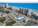 Aerial view of a beach house with a pool near the ocean and surrounding condos at 4206 S Ocean Blvd., North Myrtle Beach, SC 29582