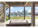 Covered porch showcasing a swing overlooking a canal and waterfront homes at 48 Sw Wilmington St., Ocean Isle Beach, NC 28469