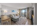 Living room with a sleeper sofa and ocean view balcony access at 4800 S Ocean Blvd. # 420, North Myrtle Beach, SC 29582