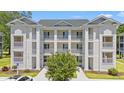 Beautiful condominium complex with multiple units, white pillars, balconies, and lush landscaping at 545 White River Dr. # 15 D, Myrtle Beach, SC 29579