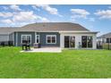 Back exterior showing a grill and nice green yard and an outdoor covered living area with sliding glass doors at 567 Hickman St., Myrtle Beach, SC 29575