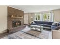 Cozy living room with a brick fireplace, large sectional sofa, and bright natural light through the windows at 605 62Nd Ave. N, Myrtle Beach, SC 29572
