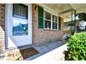 Close-up view of the brick porch with green shutters and a welcoming 'Welcome' mat at 703 S 21St Ave. S, North Myrtle Beach, SC 29582