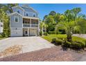 Lovely two-story home with a charming yard, double garages, and a welcoming driveway at 77 Streater Ln., Pawleys Island, SC 29585