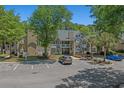 A well-maintained condo building with two stories, mature trees, and convenient parking spaces at 900 Courtyard Dr. # K7, Myrtle Beach, SC 29577