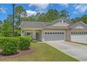 Charming home with two-car garage, light yellow siding, and beautiful landscaping at 101 Fulbourn Pl., Myrtle Beach, SC 29579
