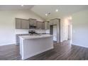 Well-lit kitchen boasts stainless appliances, grey cabinets, and a functional kitchen island at 115 Old Chimney Ln, Conway, SC 29526
