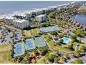 Aerial view of an oceanfront community with tennis courts, a pool, and scenic landscaping at 124 Spartina Ct. # 30, Pawleys Island, SC 29585