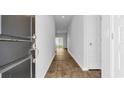 Bright hallway with wood-look flooring, white walls, and views of the living area at 1368 Palm Springs Paloma Dr, Longs, SC 29568
