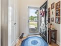 Inviting entryway featuring wood floors, a blue rug, and a stylish black door with an oval window at 210 Fox Hunt Pl., Aynor, SC 29511