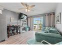 The living room features wood floors, modern furniture, and a slider to the outside balcony at 301 N Waccamaw Dr. # 110, Murrells Inlet, SC 29576