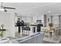 Modern kitchen with white cabinets and black appliances open to the dining and living spaces at 3175 Lyndon Dr., Little River, SC 29566