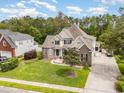 Aerial view showcasing a meticulously landscaped two-story home with a brick facade, driveway, and lush green lawn at 3564 Brampton Dr., Myrtle Beach, SC 29588