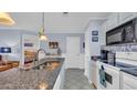 Bright eat-in kitchen with granite countertops, stainless steel sink and white cabinets at 4522 N Plantation Harbour Dr. # E-3, Little River, SC 29566