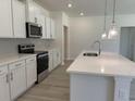 Spacious kitchen featuring a large island with quartz countertop, stainless steel appliances and light fixtures at 4750 N Huckleberry Ln., Conway, SC 29526