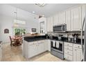 Open kitchen with white cabinets, granite countertops, and an adjoining dining area at 527 Bay Drive Ext., Garden City Beach, SC 29576