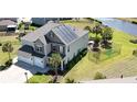 Aerial view of home featuring a well-maintained lawn, in-ground pool and solar panels by a serene pond at 5809 Oakbury Ct., Myrtle Beach, SC 29579
