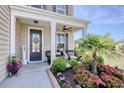 Inviting front porch with tasteful landscaping, offering a cozy seating area and welcoming entrance at 5809 Oakbury Ct., Myrtle Beach, SC 29579