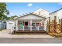 Charming beach house with a covered front porch, white siding, and colorful accents at 6001- 5718 S Kings Highway, Myrtle Beach, SC 29575