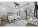 Bright main bedroom with tray ceilings, a ceiling fan, carpet and large windows at 649 W Perry Rd., Myrtle Beach, SC 29579