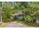 Cozy home surrounded by lush trees and greenery, complemented by a paved walkway and driveway at 6612 Wintergreen Point, Myrtle Beach, SC 29588