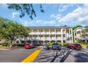 A multi-story condo building featuring white railings and stairs with ample parking at 683 Riverwalk Dr. # 302, Myrtle Beach, SC 29579