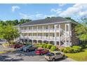 Condominium building with multiple levels, white balconies, and a parking area at 683 Riverwalk Dr. # 302, Myrtle Beach, SC 29579