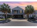 Inviting coastal home with a cozy screened porch, neutral siding, mature palm trees, and convenient covered parking at 708 Ashland Ave., North Myrtle Beach, SC 29582