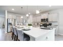 Bright kitchen showcases white cabinets, stainless steel appliances, and a center island with stylish pendant lighting at 733 Choctaw Dr., Conway, SC 29526