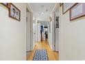 A long hallway with light colored walls and wood floors, featuring framed artwork and several doors at 806 Conway St. # 116, North Myrtle Beach, SC 29582