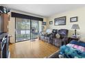 Cozy living room featuring a comfortable sofa, hardwood floors, and sliding glass doors to a balcony at 806 Conway St. # 116, North Myrtle Beach, SC 29582