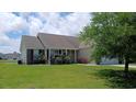 Quaint single-story home with lush landscaping and a cozy front porch, perfect for relaxing outdoors at 843 Brookline Dr., Myrtle Beach, SC 29579
