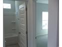 Bathroom with tile flooring and walls and white door at 8719 Baton Rouge Ave Nw, Calabash, NC 28467
