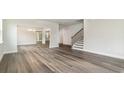 Open-concept living area with wood-look floors, staircase, and multiple entryways at 889 Ireland Dr., Longs, SC 29568