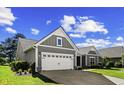 Well-maintained home featuring an attached two-car garage, and a neatly landscaped front yard at 9169 Nw Oldfield Rd., Calabash, NC 28467