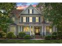 Charming two-story home with inviting front porch, columns and landscaped yard at dusk at 93 Knotty Pine Way, Murrells Inlet, SC 29576