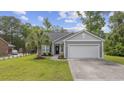 Attractive single-story home featuring well-kept landscaping, a two-car garage, and welcoming curb appeal at 103 Teal Ct., Myrtle Beach, SC 29588