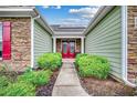 Welcoming entryway with red double doors, stone accents, and manicured landscaping at 1286 Culbertson Ave., Myrtle Beach, SC 29577